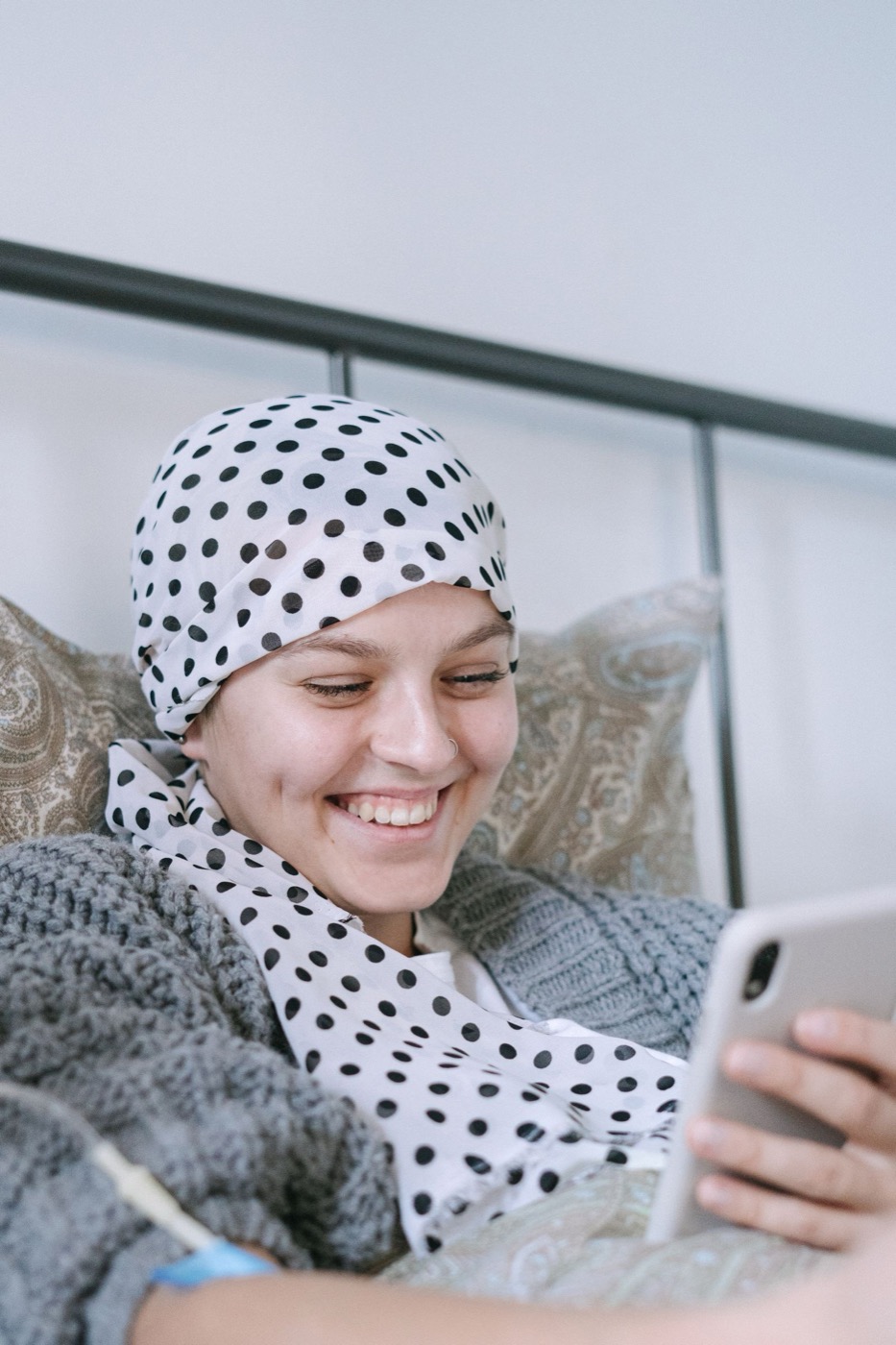 A smiling woman wearing a headscarf during cancer treatment